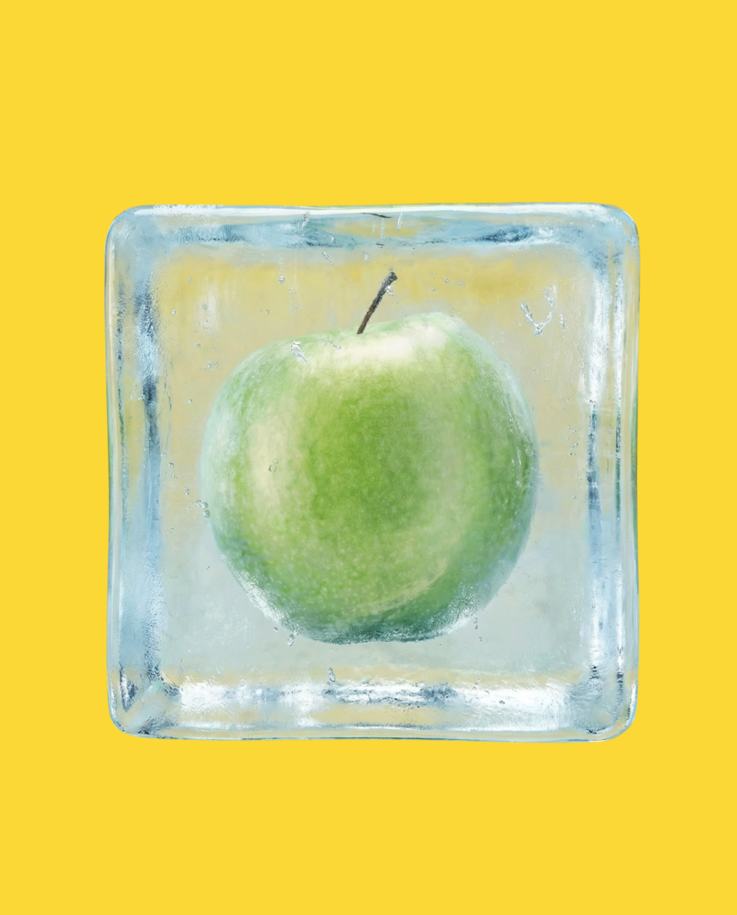 Mela verde intrappolata in un cubo di ghiaccio su sfondo giallo.